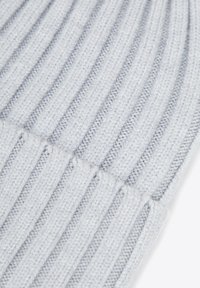 Cappellino grigio lavorato a maglia con texture a coste, caratterizzato da linee verticali e bordo ripiegato per maggiore calore e vestibilità. Morbido materiale acrilico.