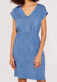 Robe bleue en tissu léger avec un décolleté en V et des manches courtes. Elle présente un motif à pois blancs subtil et une taille ajustable.