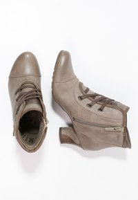 Hnědé kožené kotníkové boty s kulatou špičkou, šněrováním v přední části a bočním zipem. Masivní blokový podpatek a texturovaná podrážka pro lepší přilnavost.