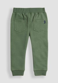 Grønne bomulds-sweatpants med ribbet talje, to baglommer og tætsiddende manchetter. Stoffet har en blød tekstur og minimal detaljering.