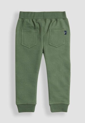 Zielone bawełniane spodnie dresowe z żebrowanym paskiem w talii, dwoma tylnymi kieszeniami i dopasowanymi mankietami. Materiał ma miękką teksturę i minimalne zdobienia.