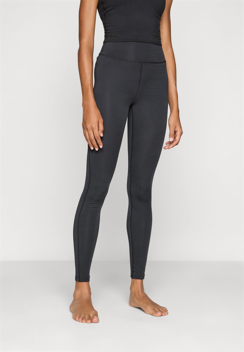 Sorte leggings lavet af strækbart stof, tætsiddende design med høj talje, glat tekstur og minimal syning.