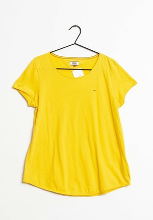 Yellow short-sleeve T-shirt with a round neckline, made of soft fabric. Features a logo emblem on the left chest area and a curved hem.