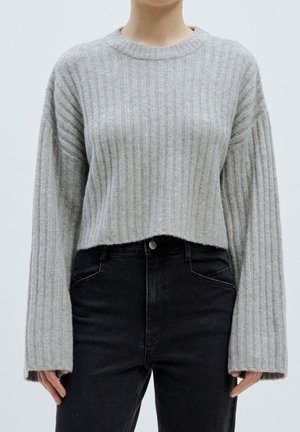 Grauer gerippter Strickpullover mit einem verkürzten Design, weiten Ärmeln und Rundhalsausschnitt, kombiniert mit high-waist schwarzen Jeans.
