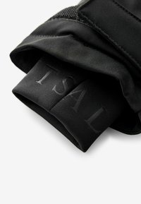 Guantes atléticos negros con un acabado de tela suave, que cuentan con una correa para la muñeca texturizada y un logotipo en relieve en el puño.
