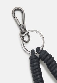 Portachiavi con corda nera, clip e anello in metallo. La clip è argentata con finitura lucida e la corda presenta un motivo intrecciato e testurizzato.