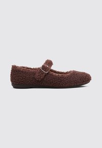 Brown plush Mary Jane flat shoe with a soft, textured exterior, featuring a buckle strap across the midfoot and a flat sole.