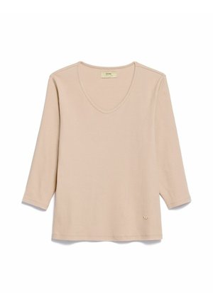 Beżowy prążkowany top z długim rękawem, dekoltem w serek i subtelną naszywką z logo przy dole, przedstawiony na płasko na białym tle.