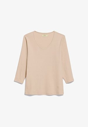 Beżowy prążkowany top z długim rękawem, dekoltem w serek i subtelną naszywką z logo przy dole, przedstawiony na płasko na białym tle.
