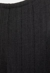 Tessuto a maglia nera con una texture a coste, caratterizzato da linee verticali e fili sottili che si alternano sulla superficie.