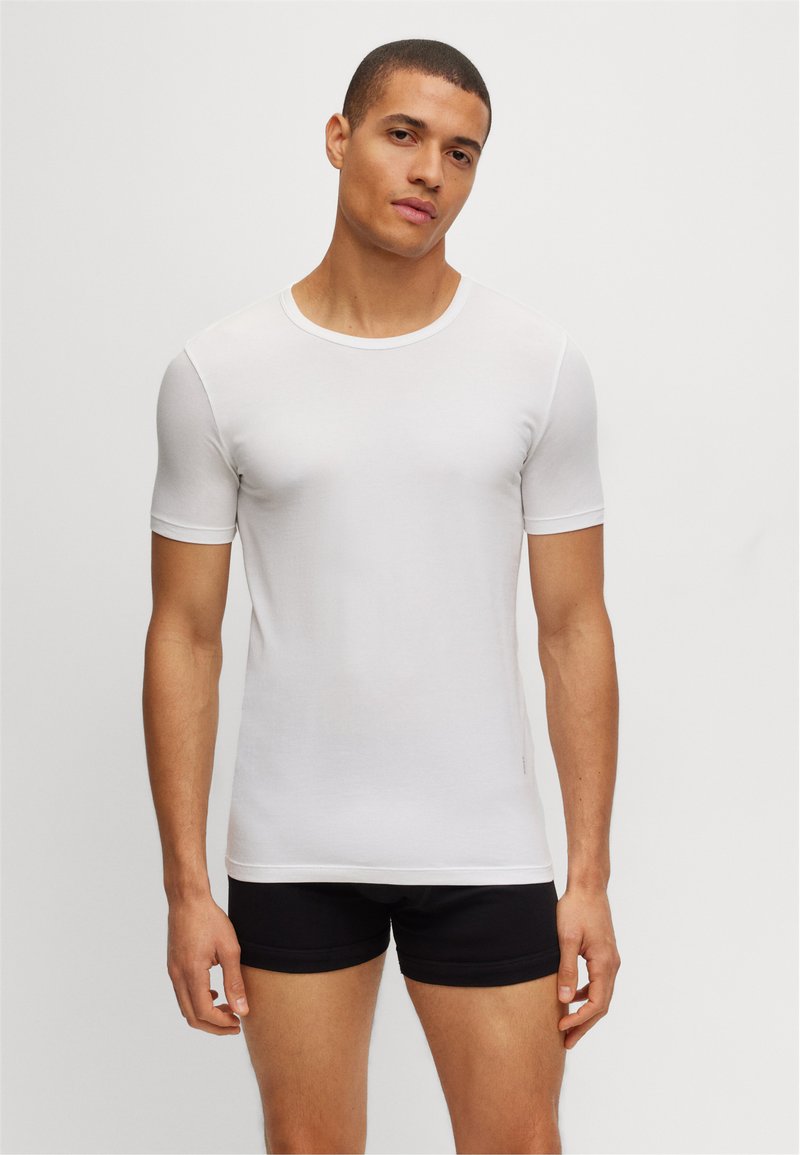 White short-sleeve t-shirt in a slim fit, made of a soft, smooth fabric. Features a classic round neckline and minimalistic design.