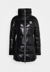 Černá péřová bunda vyrobená z lesklého, prošívaného materiálu. Obsahuje vysoký límec, přední zip a nášivku s logem na hrudi.
