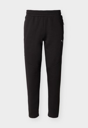 Juodos siaurėjančios sportinės kelnės su elastinga juosmens juosta, šoninėmis užtrauktukinėmis kišenėmis ir mažu Puma logotipu viršutinėje šlaunies dalyje.