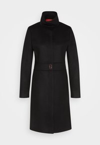 Cappotto di lana nera con colletto alto, maniche lunghe e vita con cintura. Presenta una silhouette elegante e un sottile dettaglio della fibbia lucida.