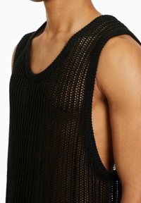 Black knitted tank top featuring a loose, open weave design, wide armholes, and a rounded neckline. The texture is lightweight and breathable.
