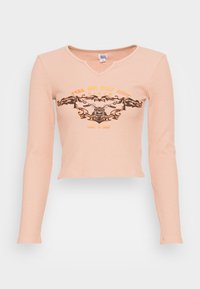 Světlý broskvový dlouhý rukáv s ribbed texturou. Má výstřih do V a přední grafiku s designem na téma motocyklů v oranžové a černé barvě.