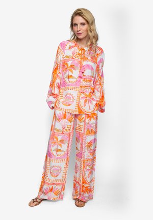 Helles zweiteiliges Outfit mit einer leichten Bluse und weit geschnittenen Hosen, verziert mit einem tropischen Muster in Pink- und Orangetönen.