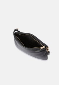 Musta nahkainen clutch, jossa on sileä pinta, kultainen vetoketju ja ohut olkahihna. Sisäpuolella on korttipaikka ja kangaspäinen vuori.