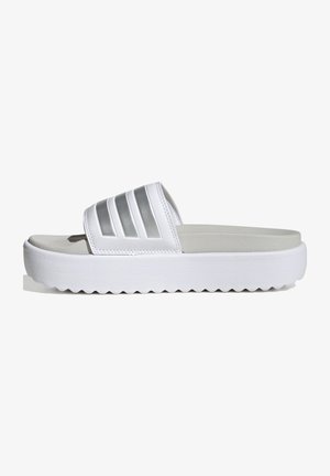 Witte slide-sandalen van synthetisch materiaal met een brede band en zilveren horizontale accenten. Dikke witte zool met zigzagpatroon.