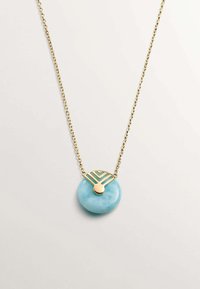 Collar de cadena de oro con un colgante de piedra redonda de color azul claro, adornado con acentos geométricos en oro y turquesa. Textura suave y acabado pulido.