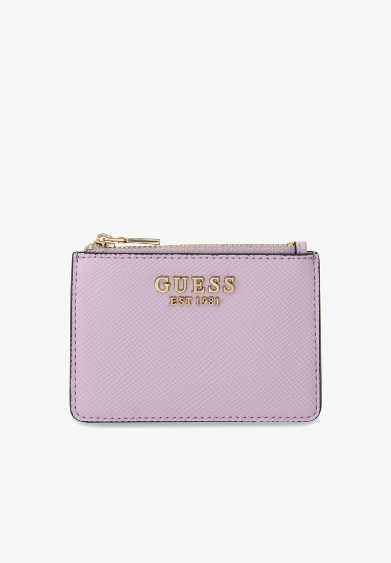 Porte-cartes en cuir texturé lavande avec logo doré "GUESS EST 1981" et tirette de fermeture éclair dorée sur le dessus.