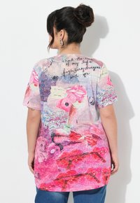 Camiseta de gran tamaño multicolor con estampado floral y texto en negro, con mangas cortas y escote redondo.