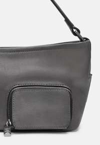 Sac à main en cuir gris présentant une texture lisse, une poche extérieure zippée et une fine sangle ajustable. Design minimaliste aux lignes épurées.