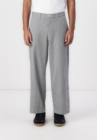 Pantaloni largi cu dungi în nuanțe de gri și alb, cu închidere cu nasture și bucle pentru curea, având o textură netedă și o croială relaxată.