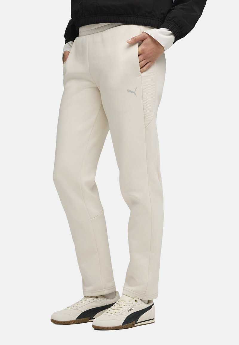 White athletic pants with a smooth texture, tapered legs, and side pockets. Features a subtle gray logo on the left leg.