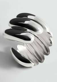 Pulsera de pulsera de plata pulida con anchas bandas segmentadas curvadas que crean un diseño de espiral abierta.