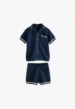 Marineblaues kurzärmliges Hemd mit weißen Paspeln und passenden Shorts mit Kordelzug und weißen gestreiften Säumen.