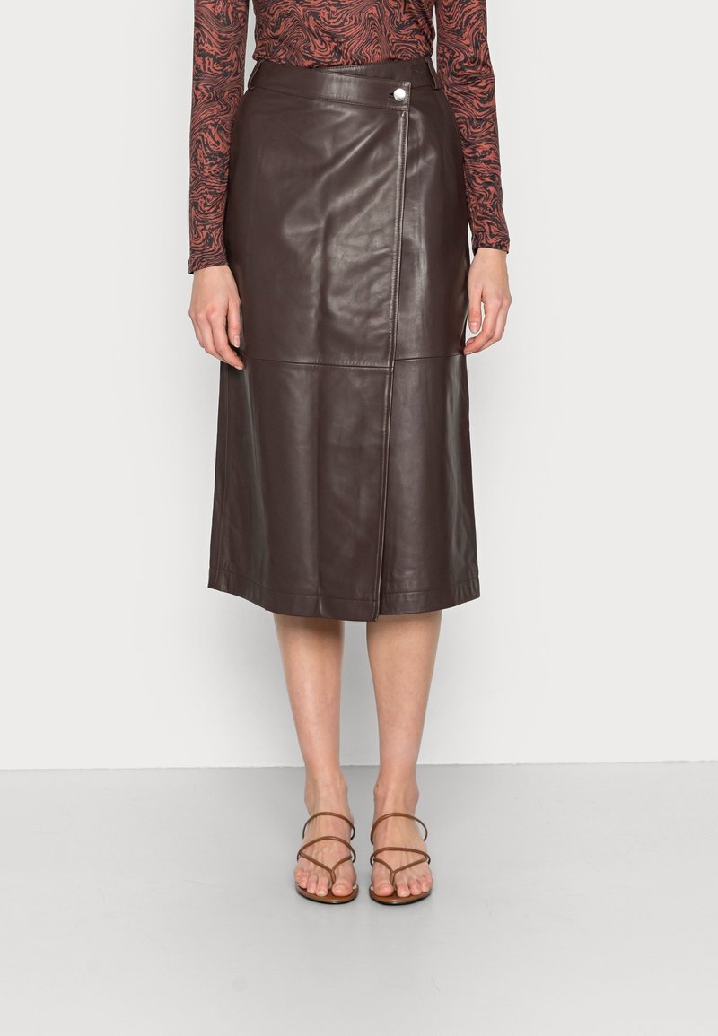 Gonna midi in pelle marrone con un design elegante, caratterizzata da una chiusura laterale a pressione, cuciture piatte e una texture liscia.