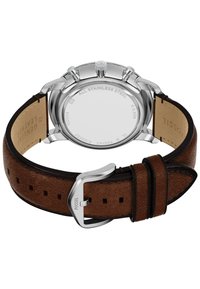 Bracelet de montre en cuir marron avec quincaillerie en acier inoxydable argenté, présente une finition texturée et des perforations visibles pour un ajustement réglable.