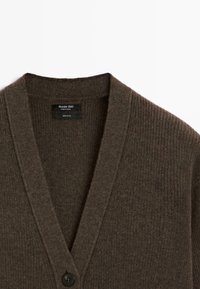 Bruine geribbelde wollen cardigan met een V-hals, voorzien van een enkele zwarte knoopsluiting en een label met de tekst Massimo Dutti, 100% wol.