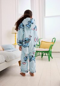 Vaaleansininen fleece-yksisarvinen, jossa on sarjakuvamaisia Stitch-kuvioita, varustettuna hupulla ja elastisilla hihoilla, suunniteltu mukavuutta ja lämpöä varten.