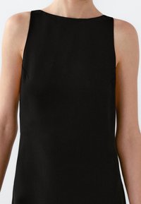 Débardeur noir sans manches avec un col rond. Tissu lisse et design ajusté, présentant des coutures minimales et sans embellissements visibles.