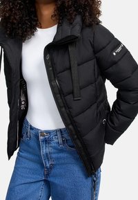 Schwarze Steppjacke mit gestepptem Design, durchgehendem Reißverschluss und Kordelzugkapuze; verfügt über Seitentaschen und ein Logo auf dem Ärmel.