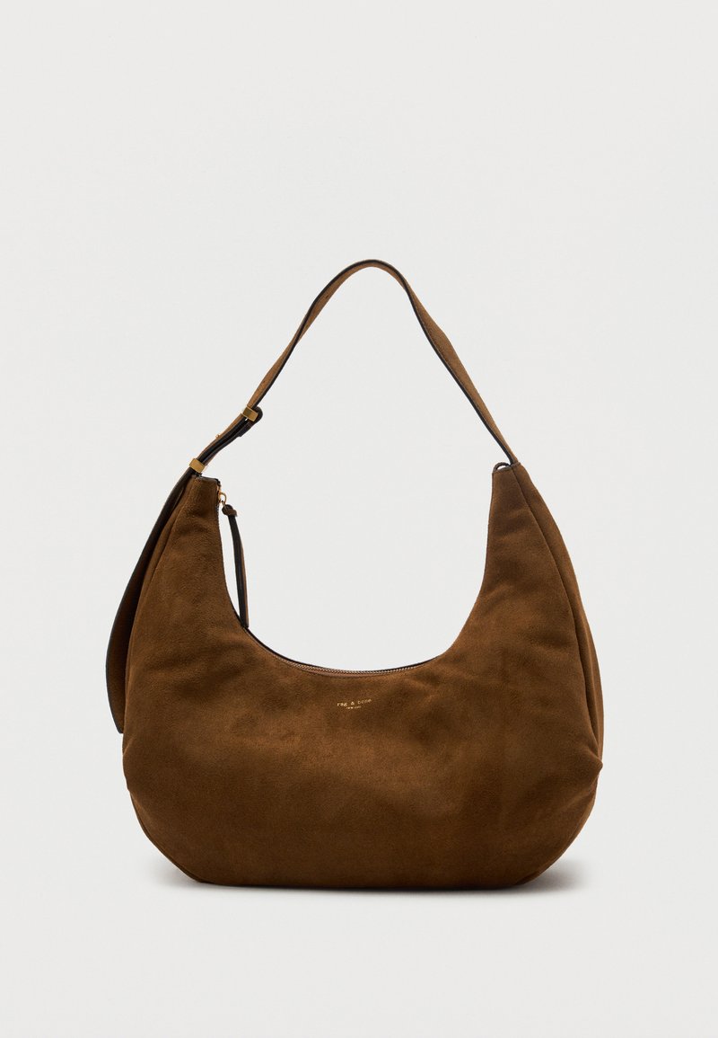 Καφέ τσάντα χόμπο από σουέντ με ευρύ ρυθμιζόμενο ιμάντα ώμου και μικρό χρυσό φερμουάρ, τοποθετημένη σε απλό ανοιχτόχρωμο φόντο.