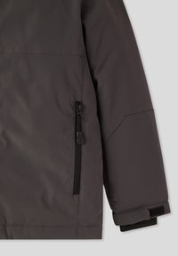 Szara wodoodporna kurtka z zamkiem błyskawicznym, gładka tekstura materiału oraz elastyczne mankiety zapewniające pewne dopasowanie.