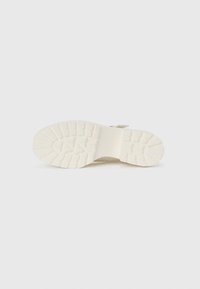 Talpă de pantof din cauciuc alb cu un model de traction texturat, formă ușor curbată și finisaj neted. Design minimalistic, fără marcaje vizibile.