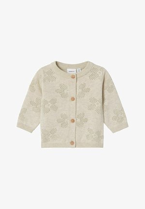 Cardigan lavorato a maglia beige con motivo floreale, scollatura rotonda, maniche lunghe e bottoni di legno sulla parte anteriore. Texture morbida e leggera.