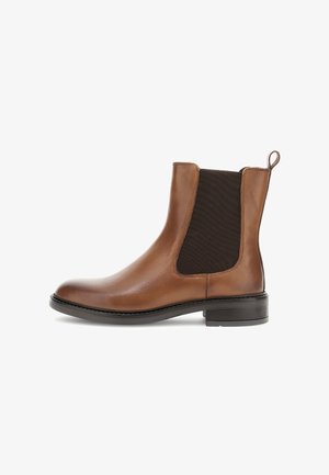 Hnědé kožené kotníkové boty s elastickými bočními panely, kulatou špičkou a nízkým černým podpatkem. Zadní poutko pro snadné obouvání. Texturovaný, hladký povrch.