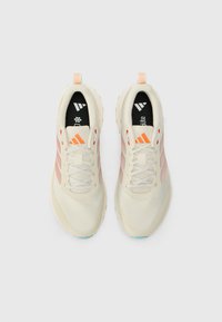 Sneakers med en cremet mesh-overdel, der har lyserøde og koralfarvede accenter, en struktureret sål og reflekterende tre-stribet branding på siderne.