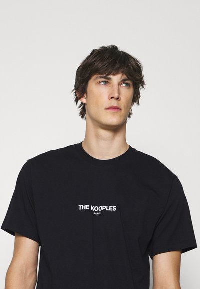 Svart bomulls t-skjorte med rund hals og kortermet, med hvit tekst "THE KOOPLES PARIS" trykt på brystet.