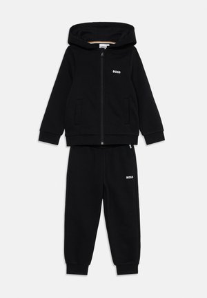 Ensemble de sweat à capuche noir et de pantalon de jogging en tissu doux. Le sweat à capuche dispose d'une fermeture éclair et de poches, les deux pièces portent un petit logo blanc "BOSS".
