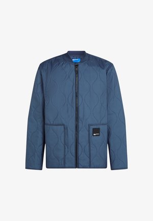 Tengerészkék steppelt dzseki kerek nyakkivágással, elülső cipzárral, két zsebbel és négyzet alakú logóval a bal zsebben. Puha tapintású.