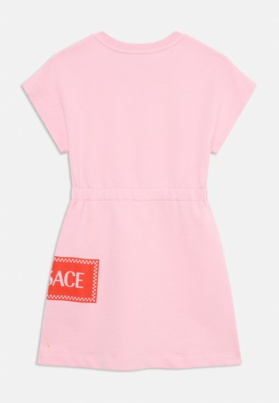 Vestido de algodão rosa com uma leve forma em A, mangas curtas e uma cintura elástica. Apresenta um patch gráfico vermelho com letras brancas.