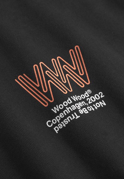 Țesătură neagră cu un design grafic portocaliu, prezentând linii ondulate. Textul include "Wood Wood Copenhagen, 2002" și "Nu trebuie să fie de încredere."