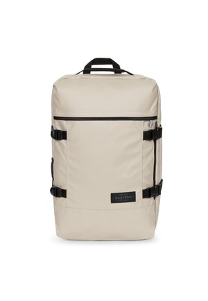 Beige rechthoekige rugzak met zwarte ritssluiting, zijgespen, bovenhandvat en Eastpak-logo op het voorvak.