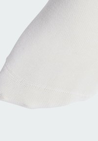 White sock featuring a smooth, knitted texture with a rounded toe. The edge showcases a reinforced seam for durability.